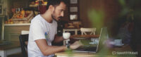 Man working at laptop inside coffee shop