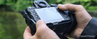 Man adjusting settings on his DSLR camera. Image: Shutterstock.com