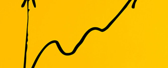 Male hand drawing a business line chart with a growing slope on yellow background. Financial profit or performance increase.